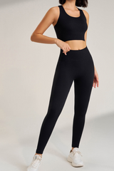 Person wearing a ribbed black sosala  athletic outfit set or bralet and leggings on a plain background