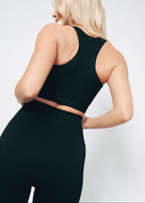 Person wearing a black rabbets athletic outfit sosala set of leggings and bralet on a white background